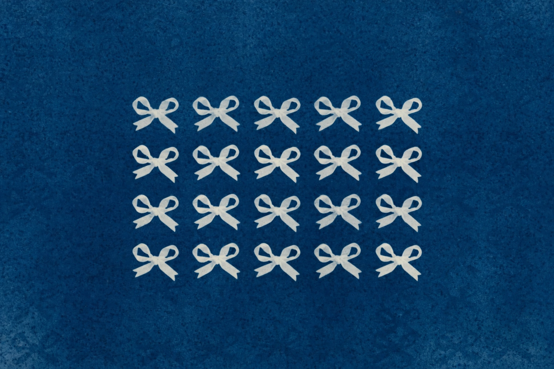 A cyanotype print shows four rows of white bows against a blue background.